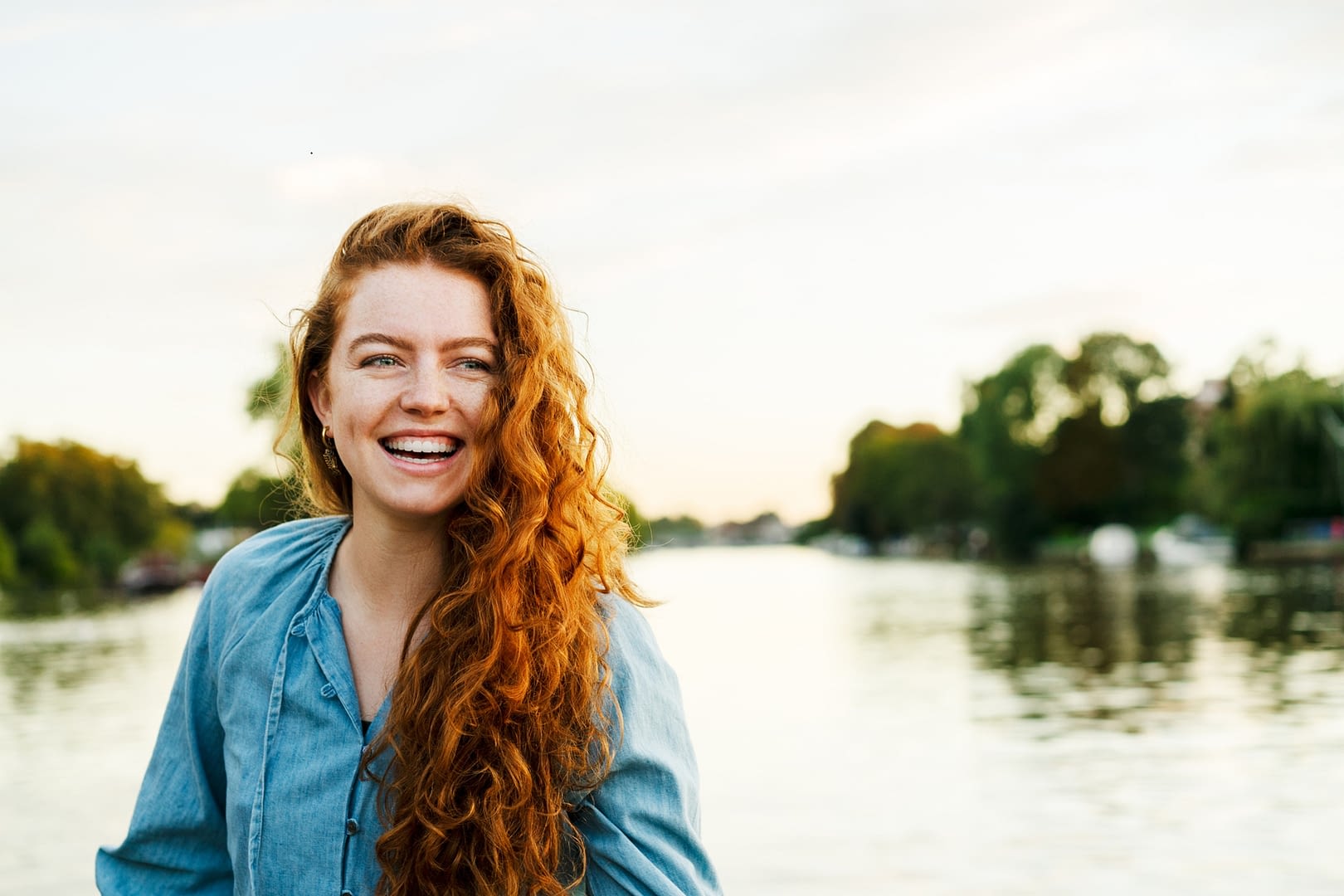 Happy woman laughing next to water