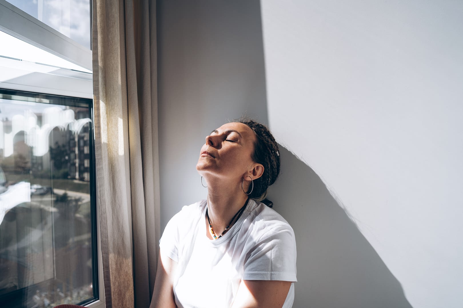 woman sitting by window appearing angry or sad