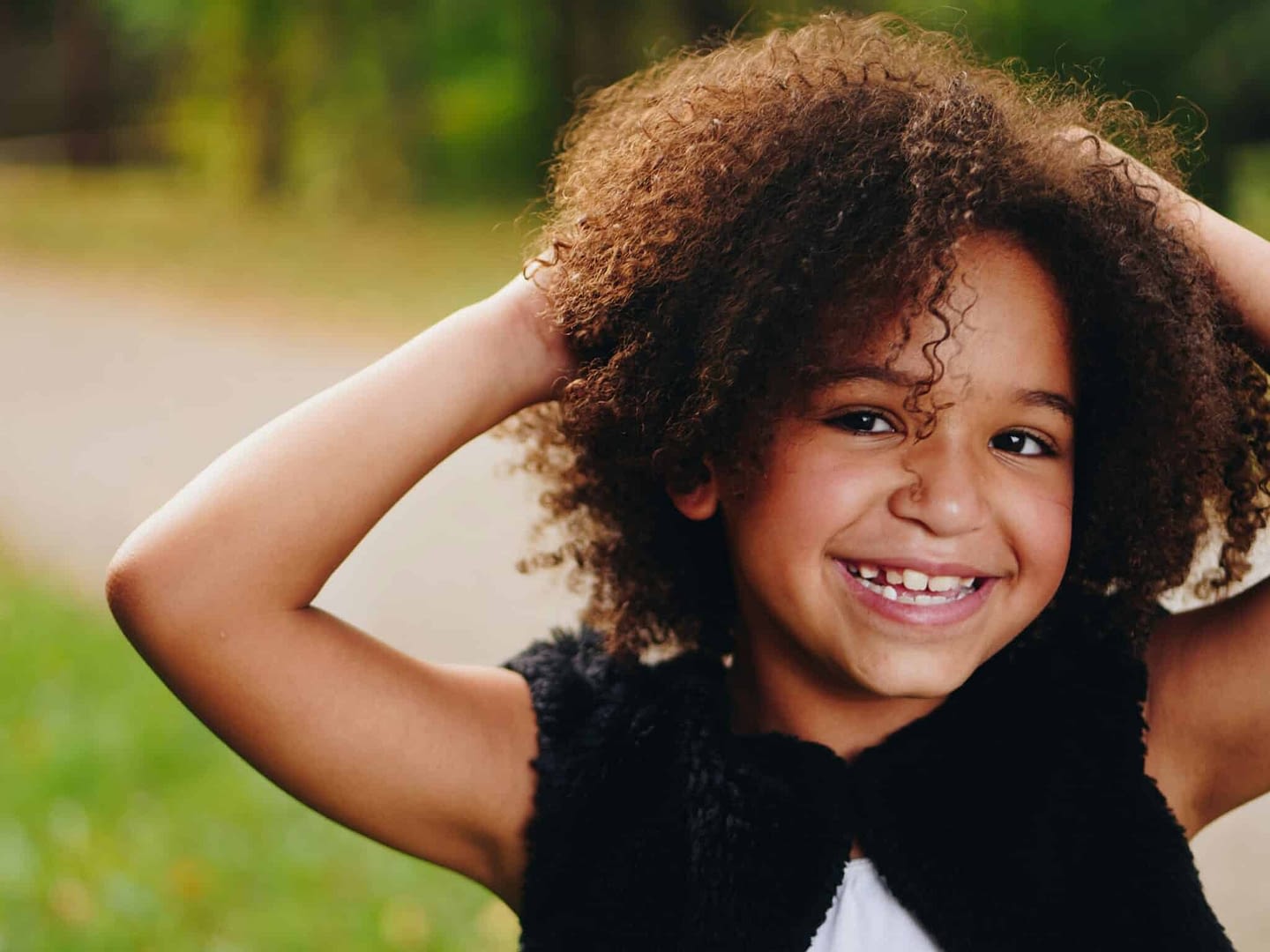 young mixed race girl smiling with hands behind her head