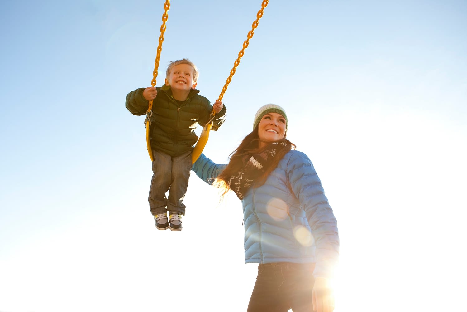 Mom pushing son on a swing