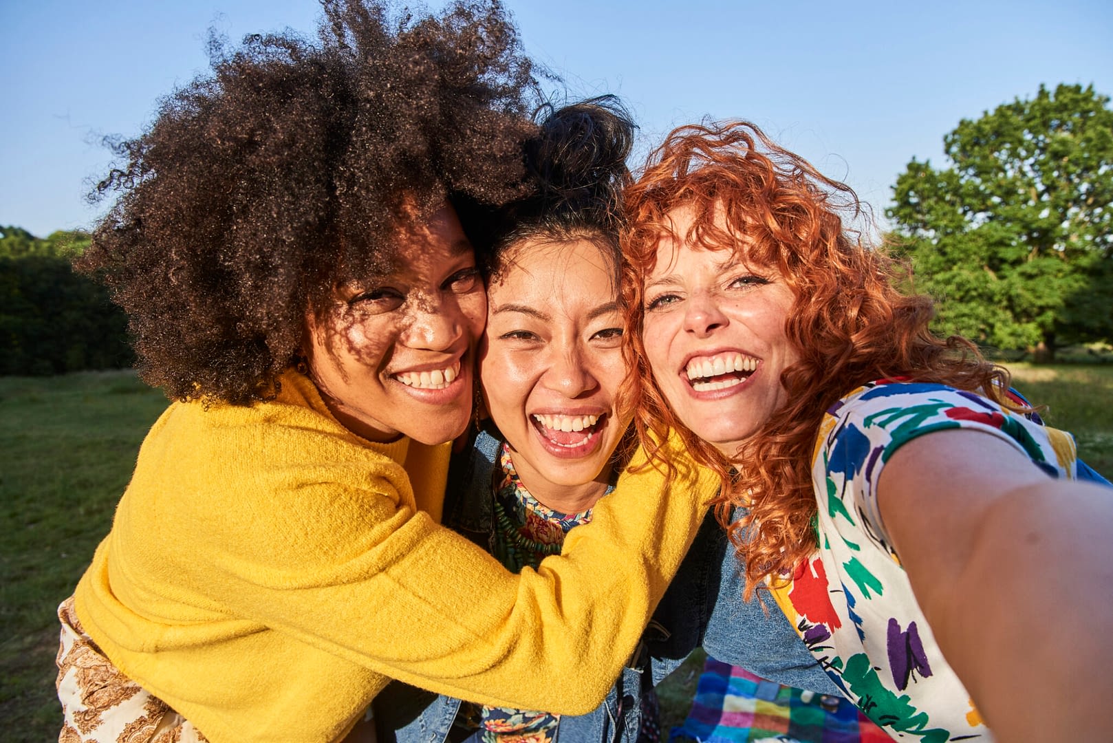 group of three women friends smiling