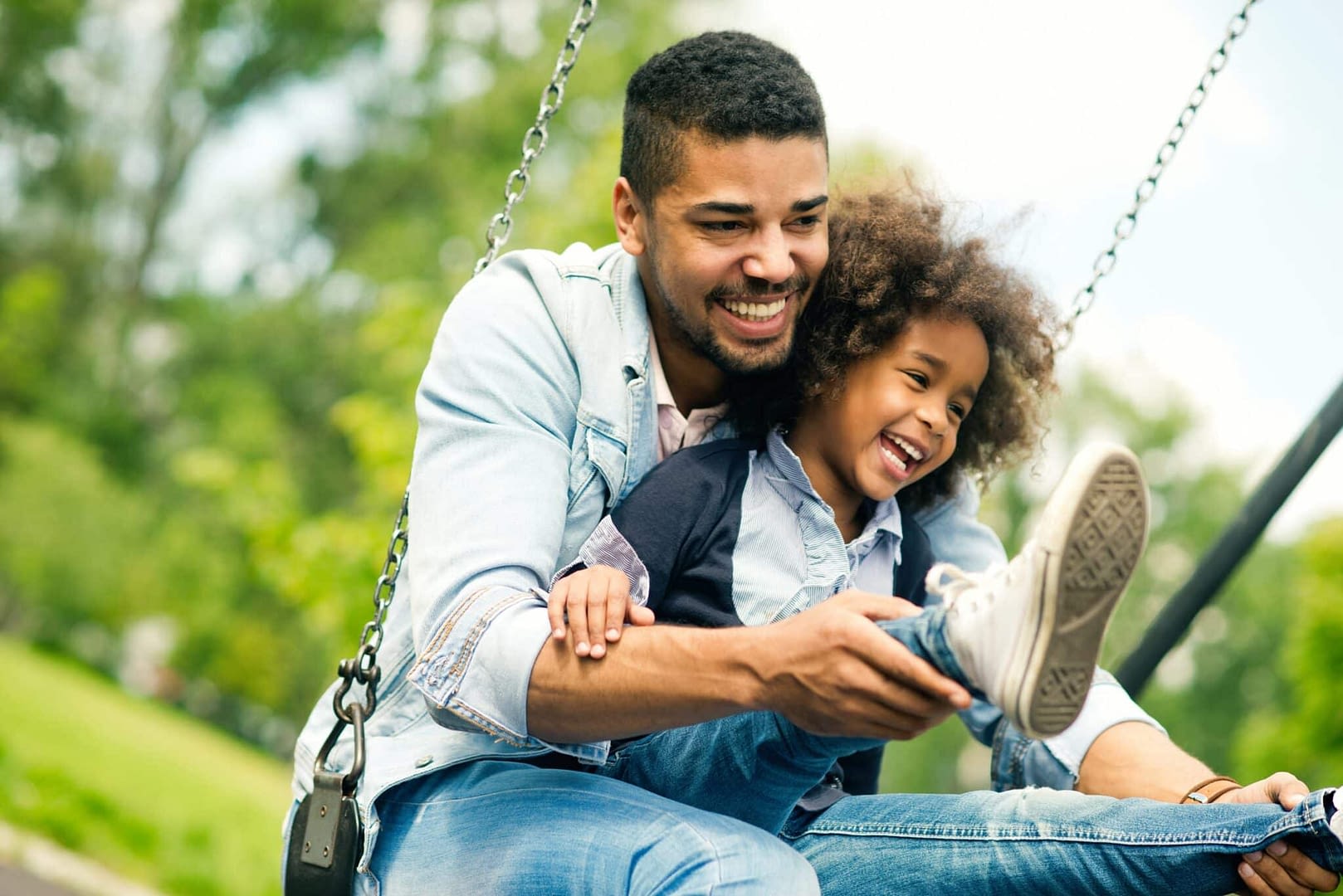 father swinging with son on swing