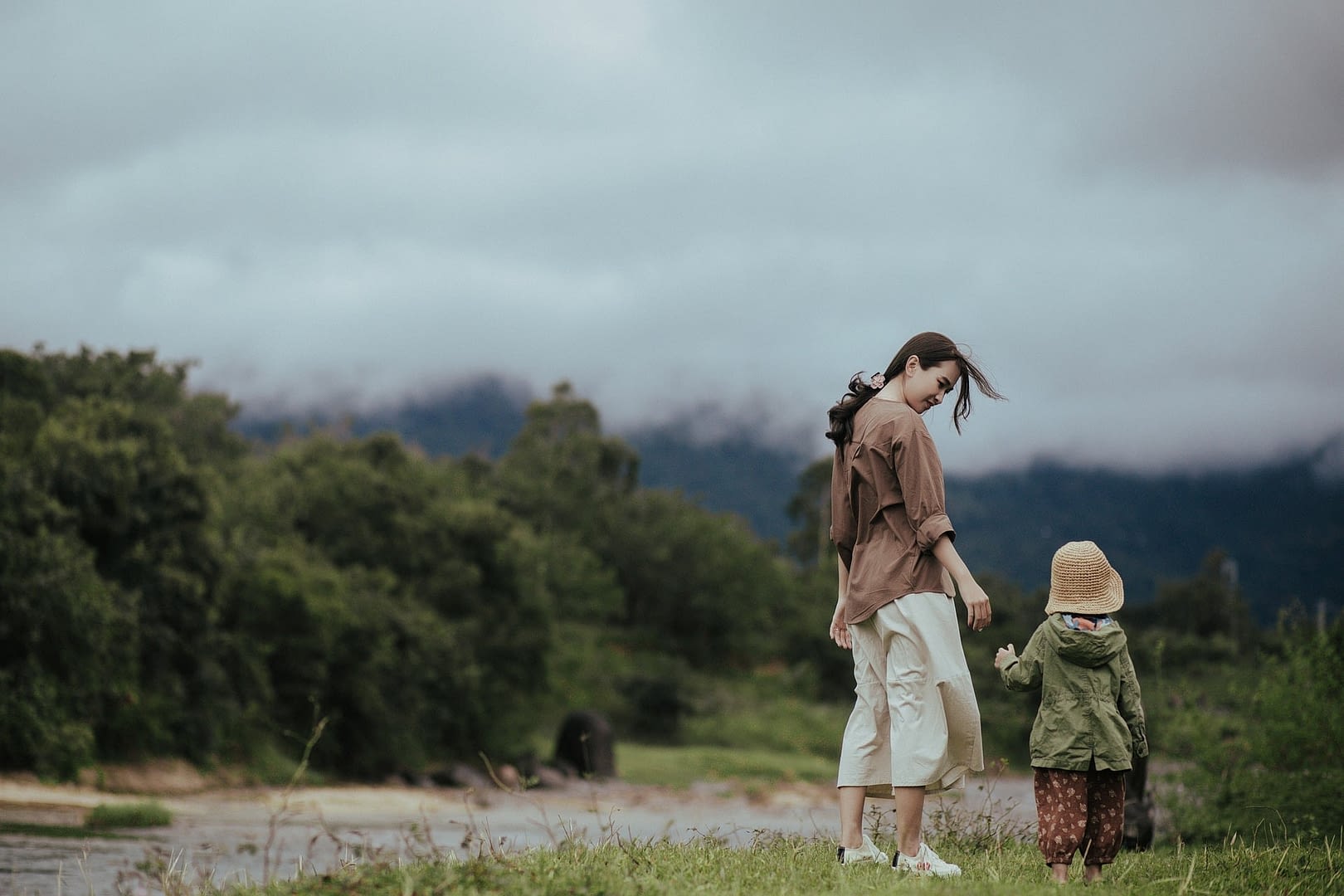 mother walking outside on cloudy day with child