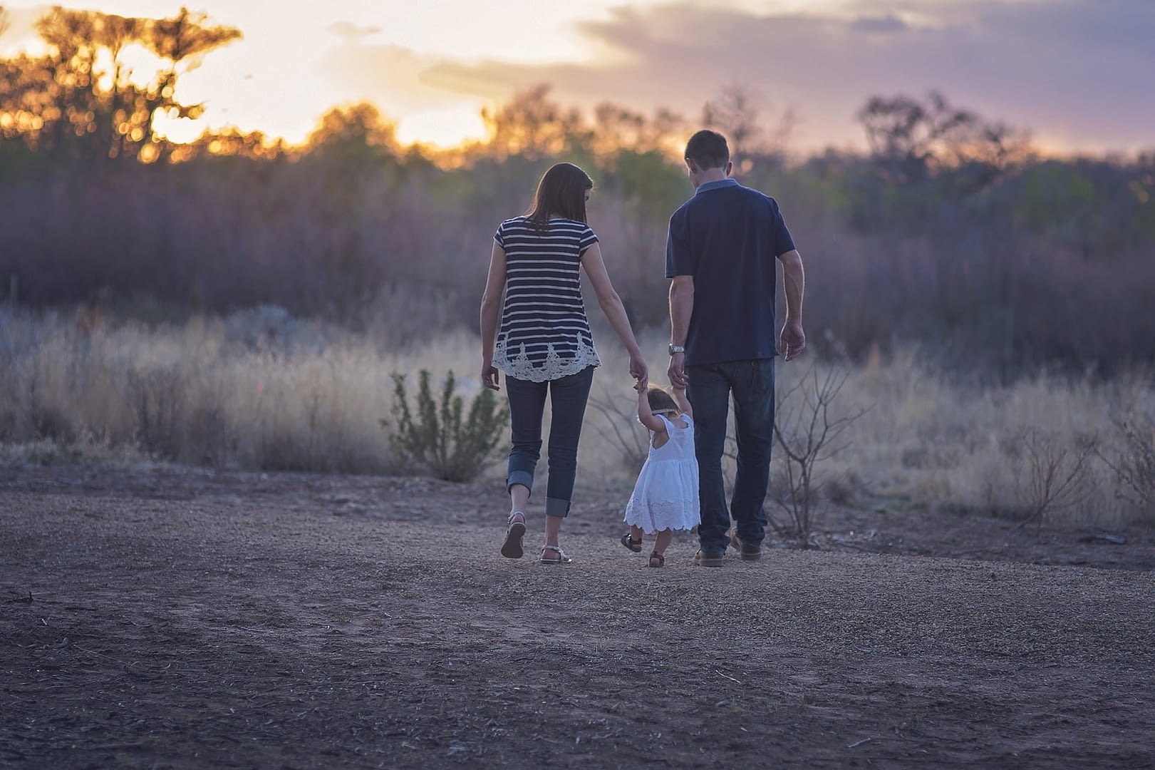 family walking outside during sunset