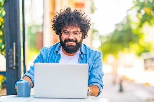 happy man using laptop outside