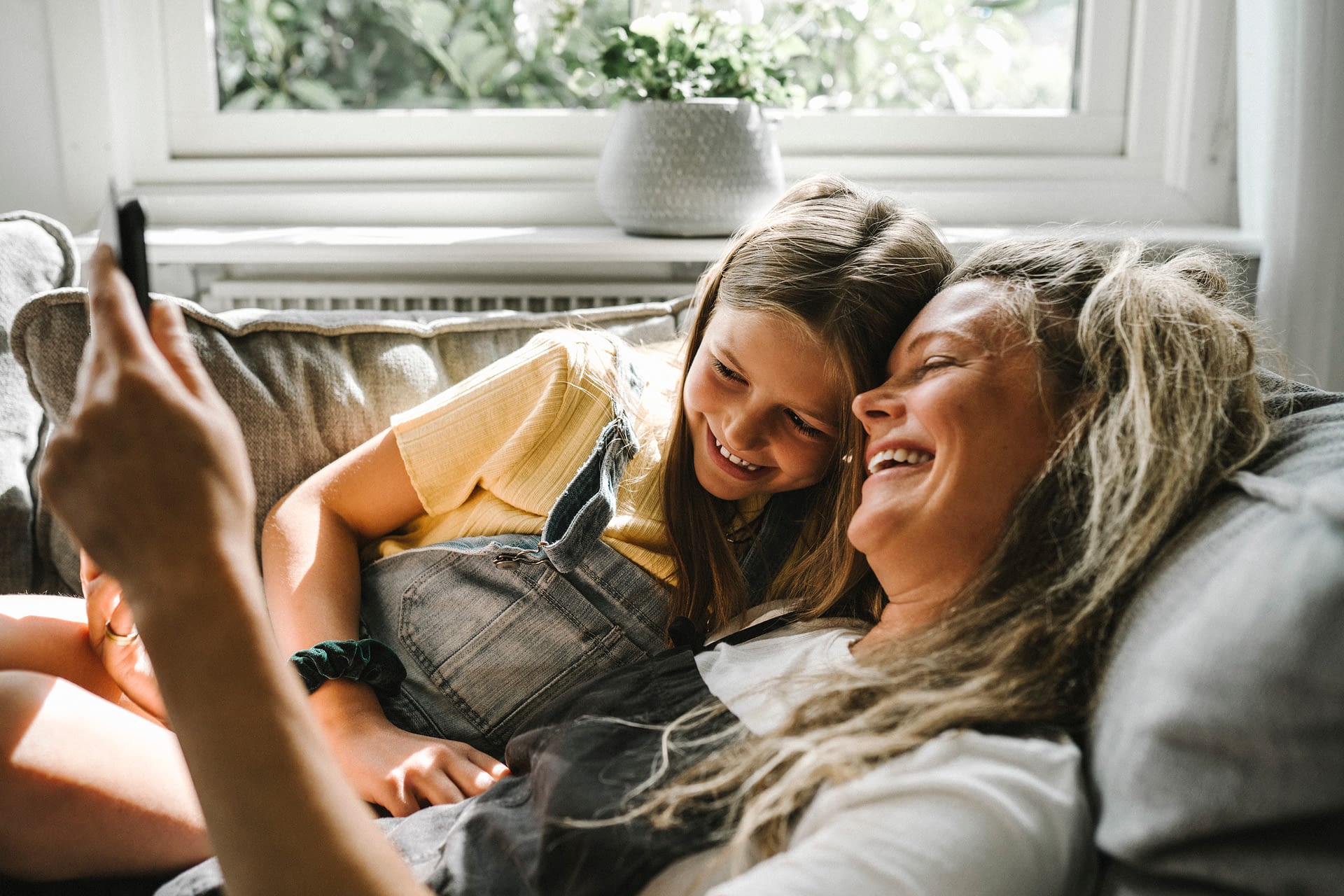mother and daughter laying on couch