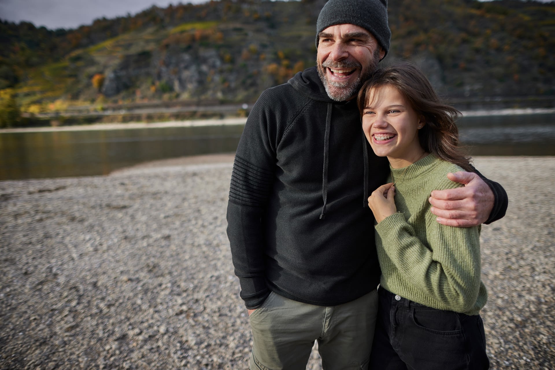 father and daughter on river bank
