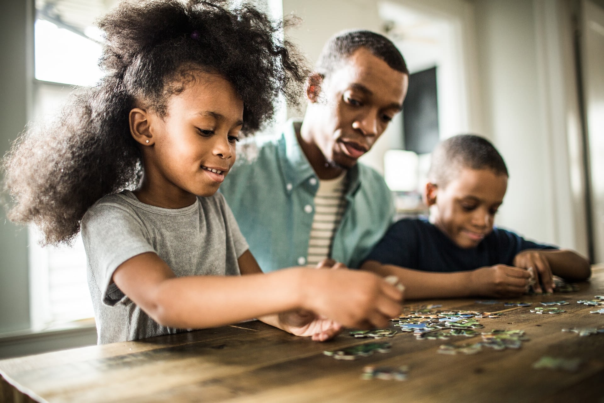 father and kids doing a puzzle
